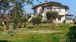 Una casa a due piani con un giardino davanti.