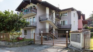 A multi-story residential building with balconies, a gated entrance, and a driveway. - GARDASUN 2 - Lovely flat Lake close Pet friendly (Padenghe Sul Garda)