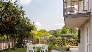 A patio with a table and chairs, surrounded by greenery and a fence. - GARDASUN 2 - Lovely flat Lake close Pet friendly (Padenghe Sul Garda)