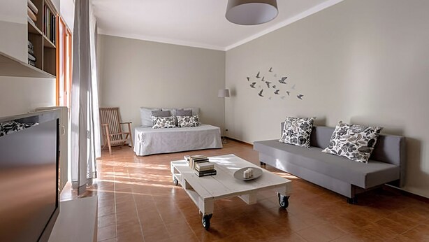 A modern living room with a sofa, a coffee table, a bed, and a bookshelf. - Natural Chic - ON THE BEACH ON FOOT (Desenzano del Garda)