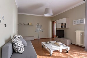 Una sala de estar moderna con un sofá, una mesa de centro, un televisor y un radiador.