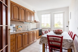 Enjoy cooking in this well-equipped kitchen with a dining table and ample natural light.