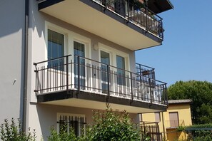 Un edificio de dos pisos con balcones, ventanas amplias y un cielo despejado.