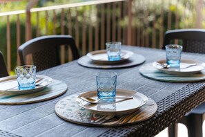 Una mesa de comedor dispuesta con platos, cubiertos y vasos.
