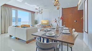 Une chambre d’hôtel moderne dotée d’un coin repas, d’un canapé et d’une télévision.