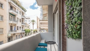 A balcony with a seating area, a small table, and a vertical garden. - The Luxury Suite by Cloudkeys (Athens)