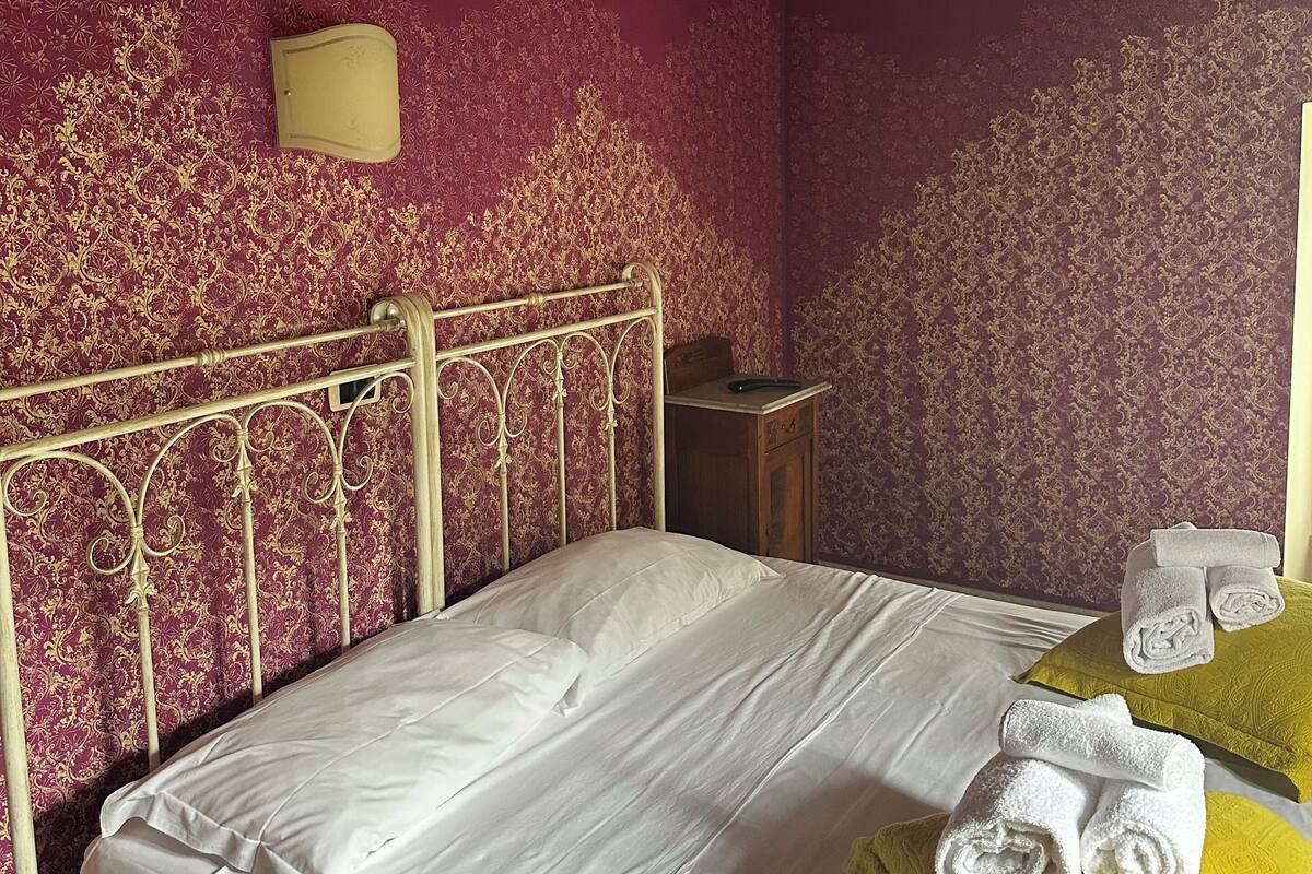 Ein Schlafzimmer mit einem Bett, einem Nachttisch und einer Wandlampe.