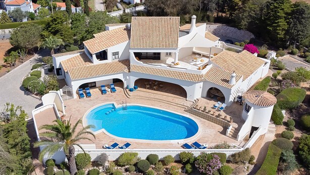 Eine großzügige, moderne Villa mit Pool, mehreren Balkonen und einem gepflegten Garten.