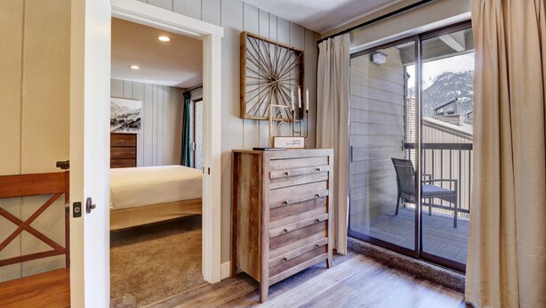 Une chambre à coucher avec un lit, une commode et une vue sur le balcon.