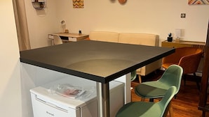 Une cuisine de taille réduite comprenant un réfrigérateur, une table à manger et deux chaises.