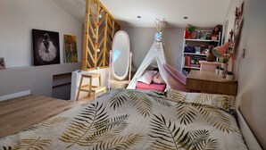 A bedroom with a bed, a vanity with a mirror, a wooden ladder, a bookshelf, and a tent-like structure. - Quiet house in Provence (Saint-Cannat)