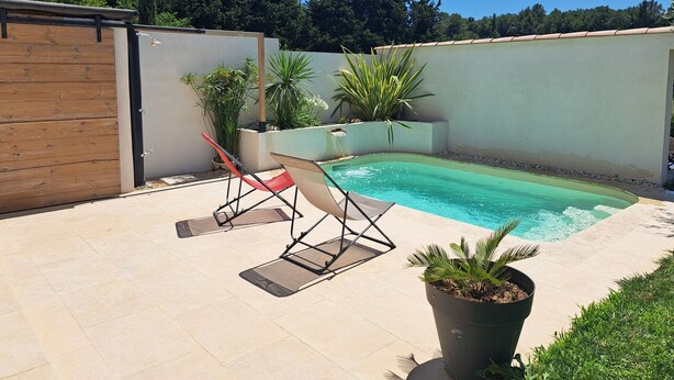 A backyard with a swimming pool, two lounge chairs, and potted plants. - Quiet house in Provence (Saint-Cannat)