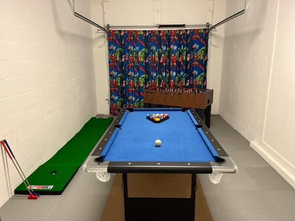 Una mesa de billar con superficie de fieltro verde, una bola blanca y un fondo colorido.