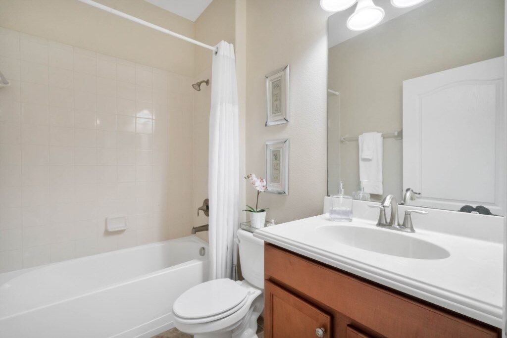 A bathroom with a bathtub, toilet, and sink.