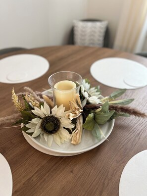 A round table with a candle holder containing a candle, surrounded by dried flowers and greenery. - This place is peaceful  to stay in, Relax and enjoy. (Greenville)