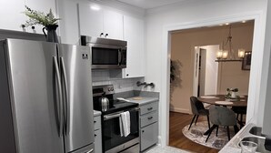 A modern kitchen with stainless steel appliances, a microwave, and a dining area with a wooden table and chairs. - This place is peaceful  to stay in, Relax and enjoy. (Greenville)