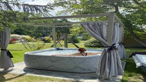 A hot tub in a covered outdoor area with a pergola overhead. - Holiday Home near Baltic Sea & Golf Course (Kołczewo)
