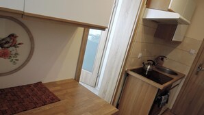Una cucina con un piano di lavoro in legno, un bollitore e un lavandino.