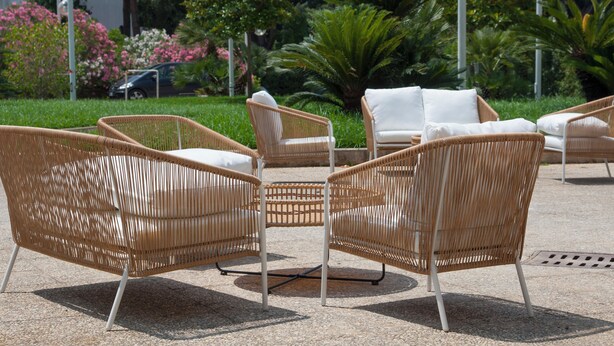 Wicker chairs with white cushions arranged on a patio. - Hotel Centrale (Sabaudia)