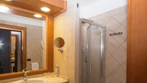 A bathroom with a sink, mirror, and shower. - Hotel Centrale (Sabaudia)