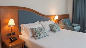 A hotel room with a bed, two bedside lamps, a telephone, and a chair. - Hotel Centrale (Sabaudia)
