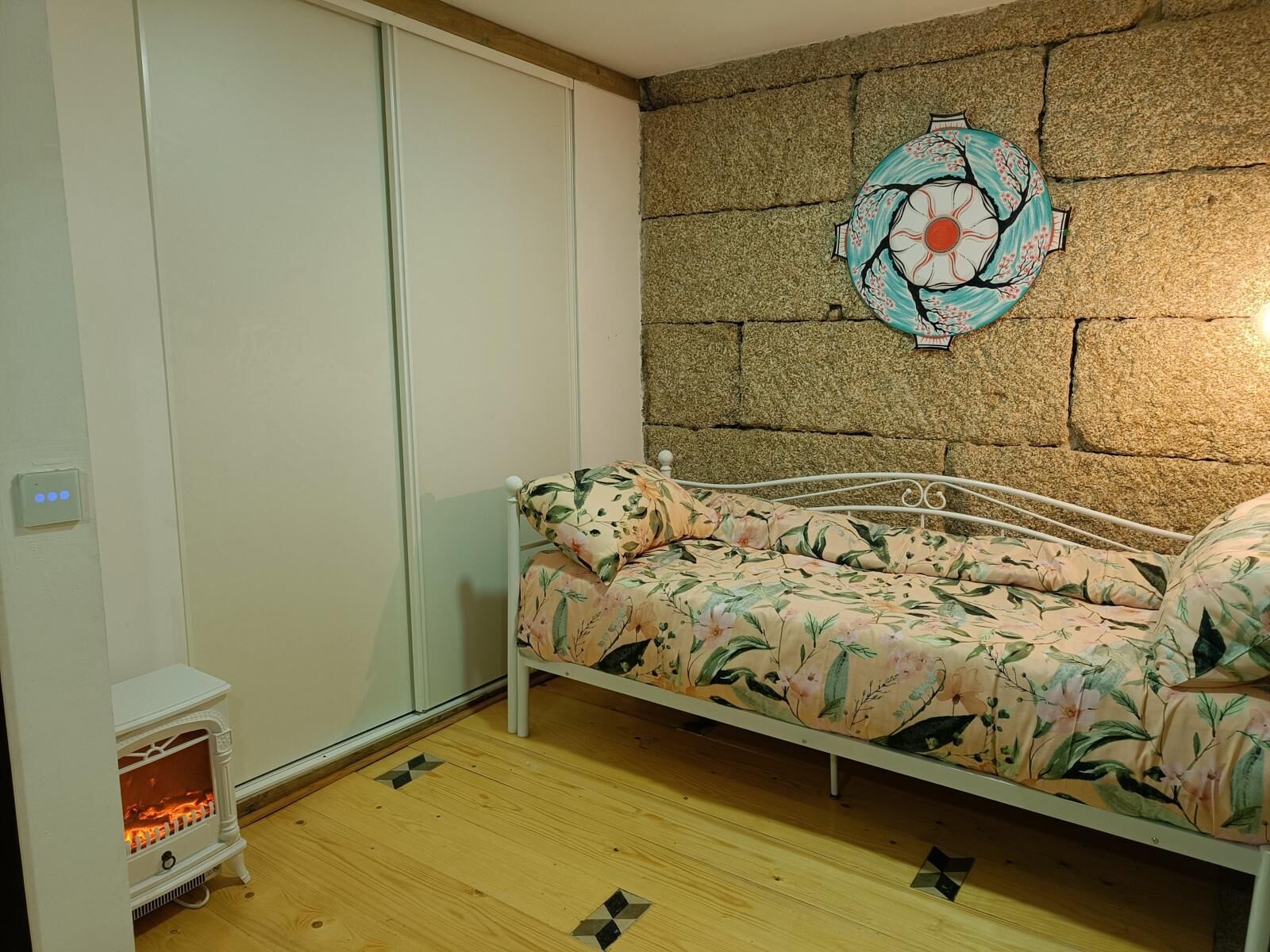 Una camera da letto con un letto, un termosifone a parete e un elemento decorativo.