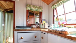 Una cucina con mobili in legno, un piano di lavoro e una finestra con tende.