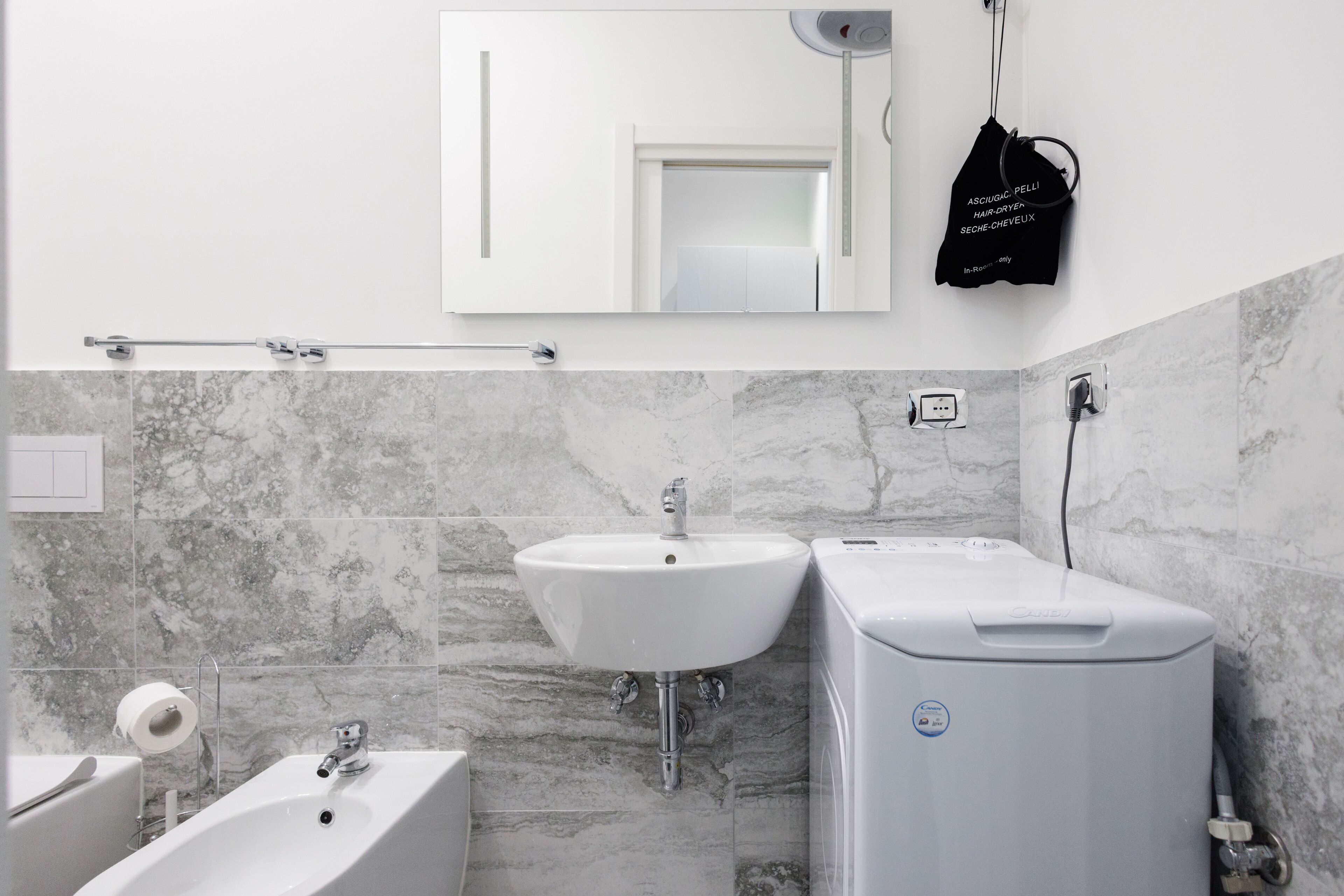 Un baño moderno con lavamanos blanco, bañera y calentador de agua.
