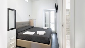 Un dormitorio moderno con cama, cómoda, espejo y ventana.
