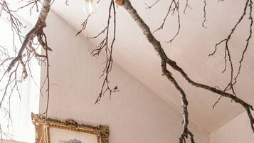 Una habitación con estantería, un cuadro enmarcado y una lámpara colgante.