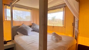 A room with two beds, each with white bedding and pillows, a small bedside table, and a window with curtains. - Seaside Serenity: Luxury Glamping Getaway - Sleeps 6 (St Peters)
