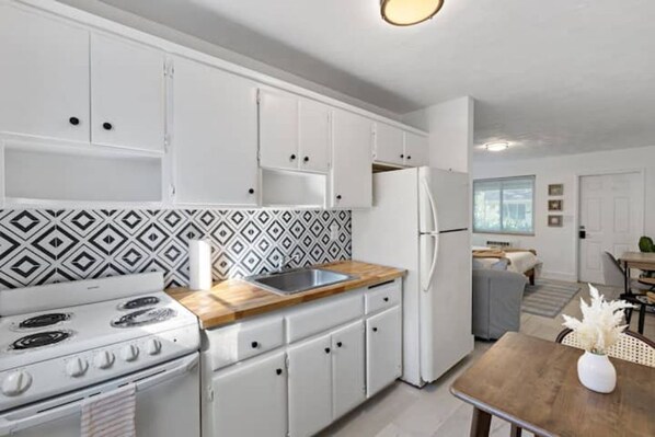 Effortlessly cook and dine in this well-equipped kitchen with a stove, sink, and refrigerator.
