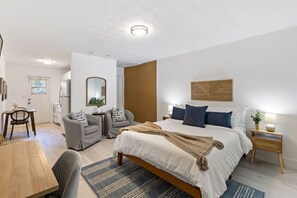 Relax in this serene bedroom with a large bed, dining table, and comfortable seating area.