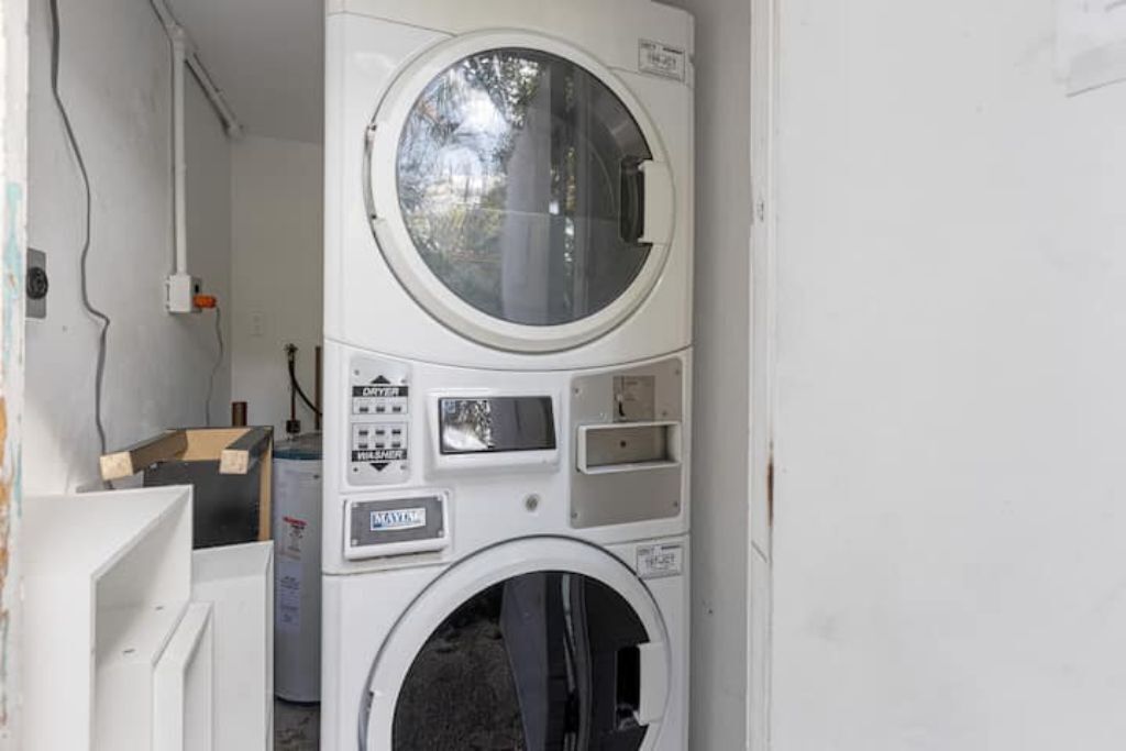 A front view of a stacked washer and dryer unit with control panels and a circular window.