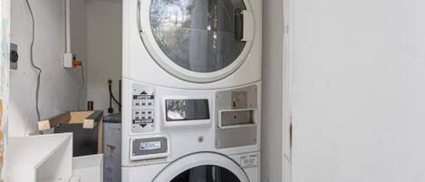 A front view of a stacked washer and dryer unit with control panels and a circular window.