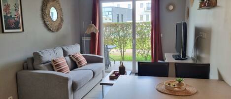 Un salon avec un canapé, une table à manger et un téléviseur.