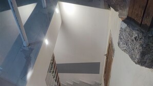 A staircase leading to a landing with a metal railing and a door. - A 2 pas des Étangs, Calme et Spacieux Bienvenue a Peyriac de mer (Peyriac-de-Mer)