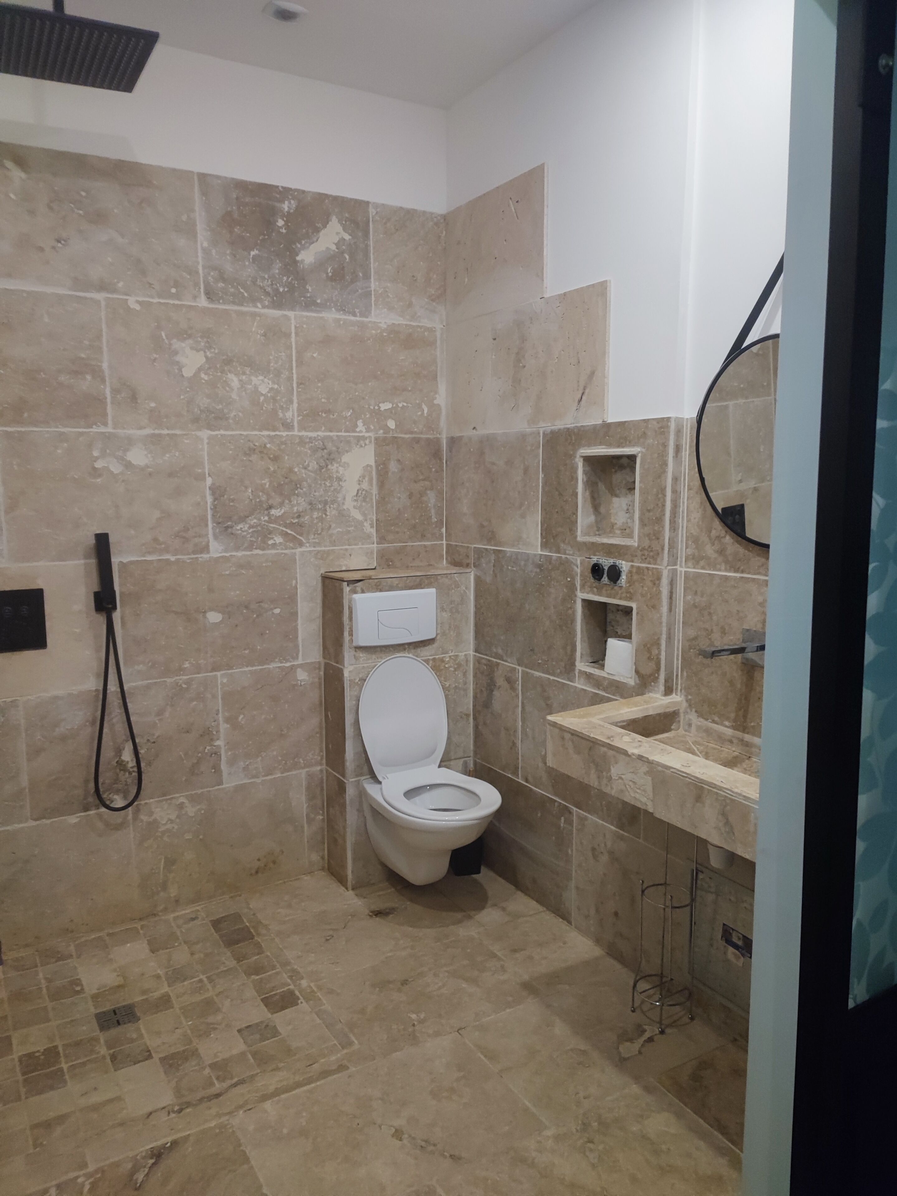 Une salle de bain avec des toilettes, un lavabo et un miroir.