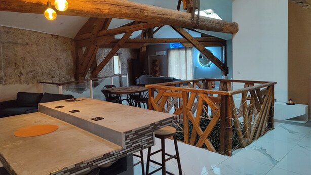 A rustic interior with exposed wooden beams, a high ceiling, and a dining area with a table and chairs. - A 2 pas des Étangs, Calme et Spacieux Bienvenue a Peyriac de mer (Peyriac-de-Mer)