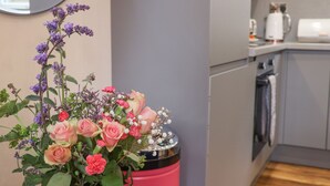 A kitchen with a pink trash bin, a coffee maker, and a microwave. - Routh Retreat (Whitby)