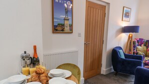 A dining area with a table set for breakfast, including croissants, plates, and a coffee pot. - Routh Retreat (Whitby)