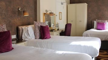 Een hotelkamer met twee bedden, een kast, een spiegel en een lamp.