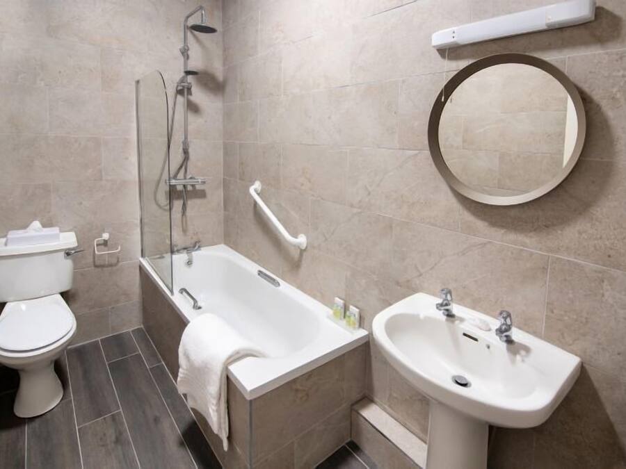 Un baño moderno con inodoro, bañera y lavamanos.