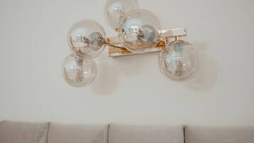 A wall-mounted light fixture with four clear glass globes and a gold-colored metal structure.