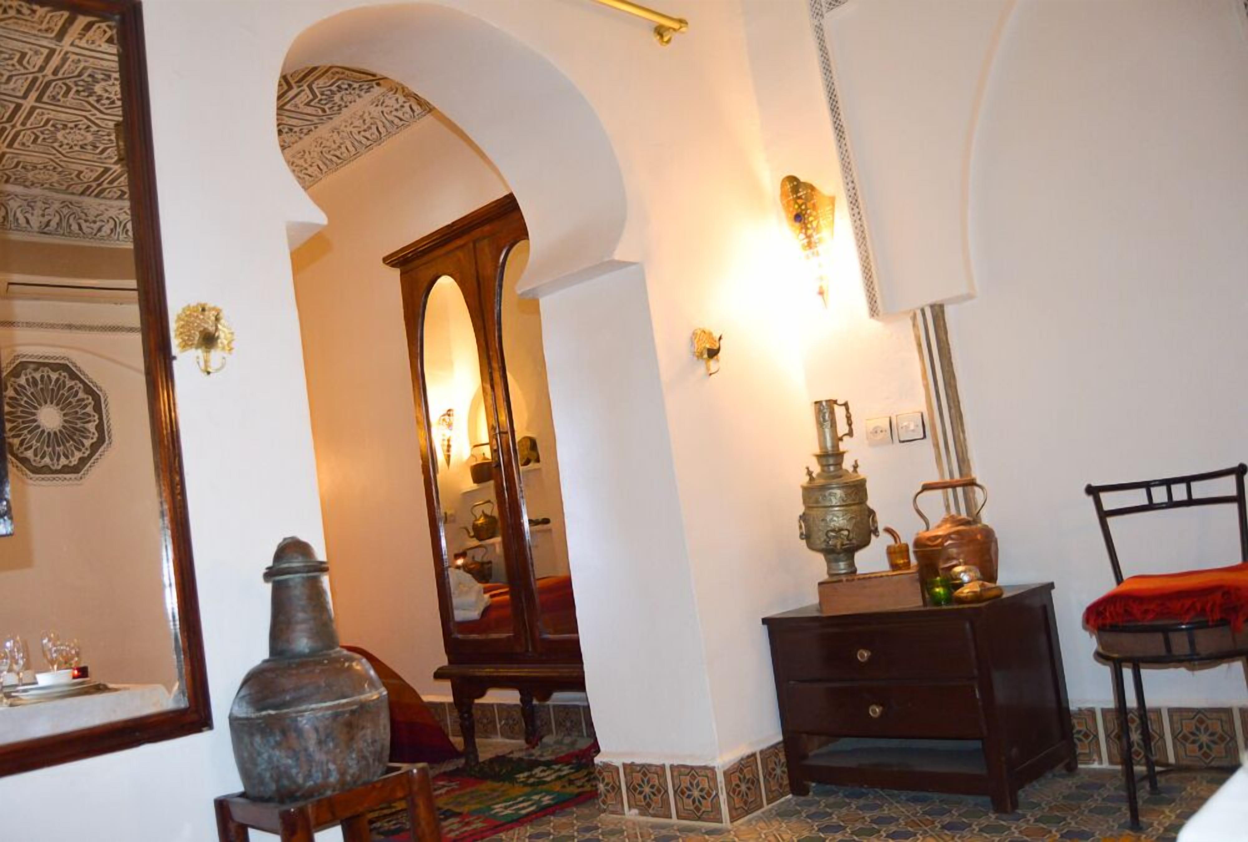 A room with a large mirror, a wooden cabinet, and a patterned rug.