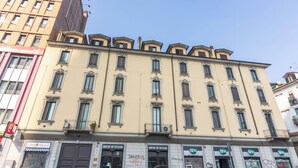 A multi-story building with a beige facade, multiple windows, and balconies. - OurJoy Condo, 55sm, free private parking and breakfast, high-speed WIFi and A/C (Milano)