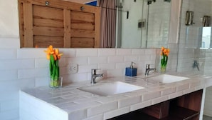 A modern bathroom with two sinks, a wooden vanity, and a large mirror.