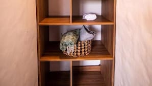 A wooden closet with multiple shelves and hanging space.