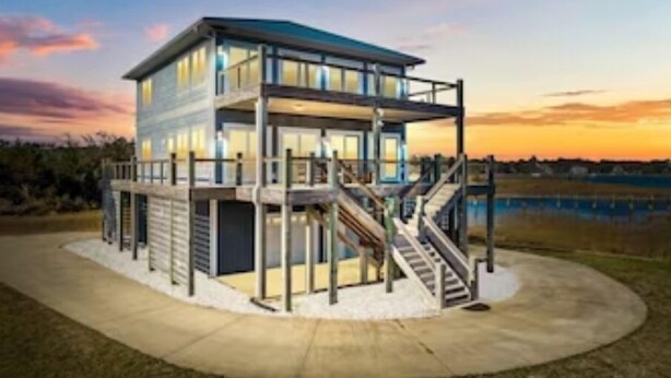 A modern multi-story building with a glass facade, a covered outdoor area, and a staircase leading to the upper levels. - OCEAN VIBES ON THE INTRACOASTAL (Wilmington)