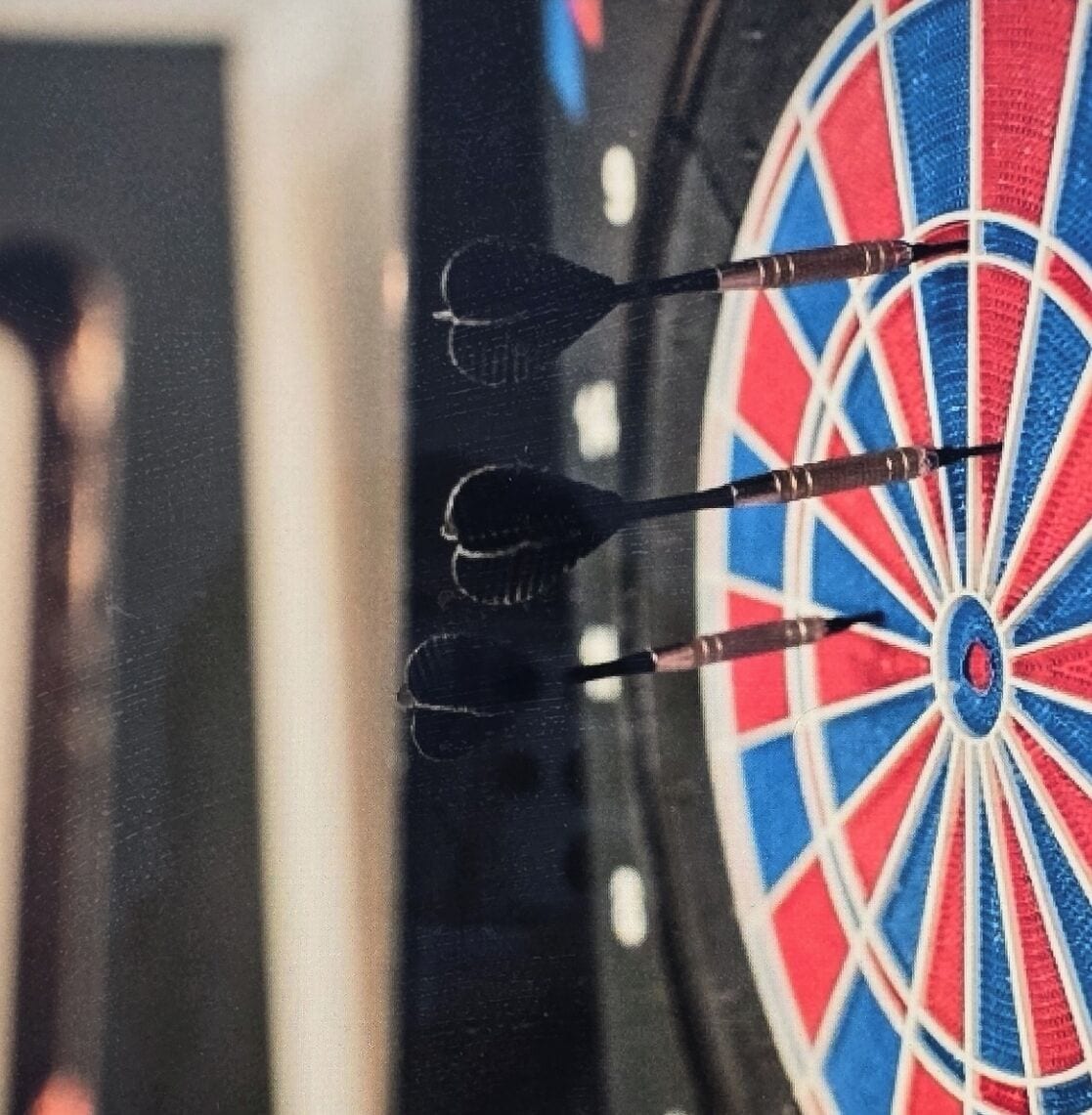 A dartboard with three darts in the center.